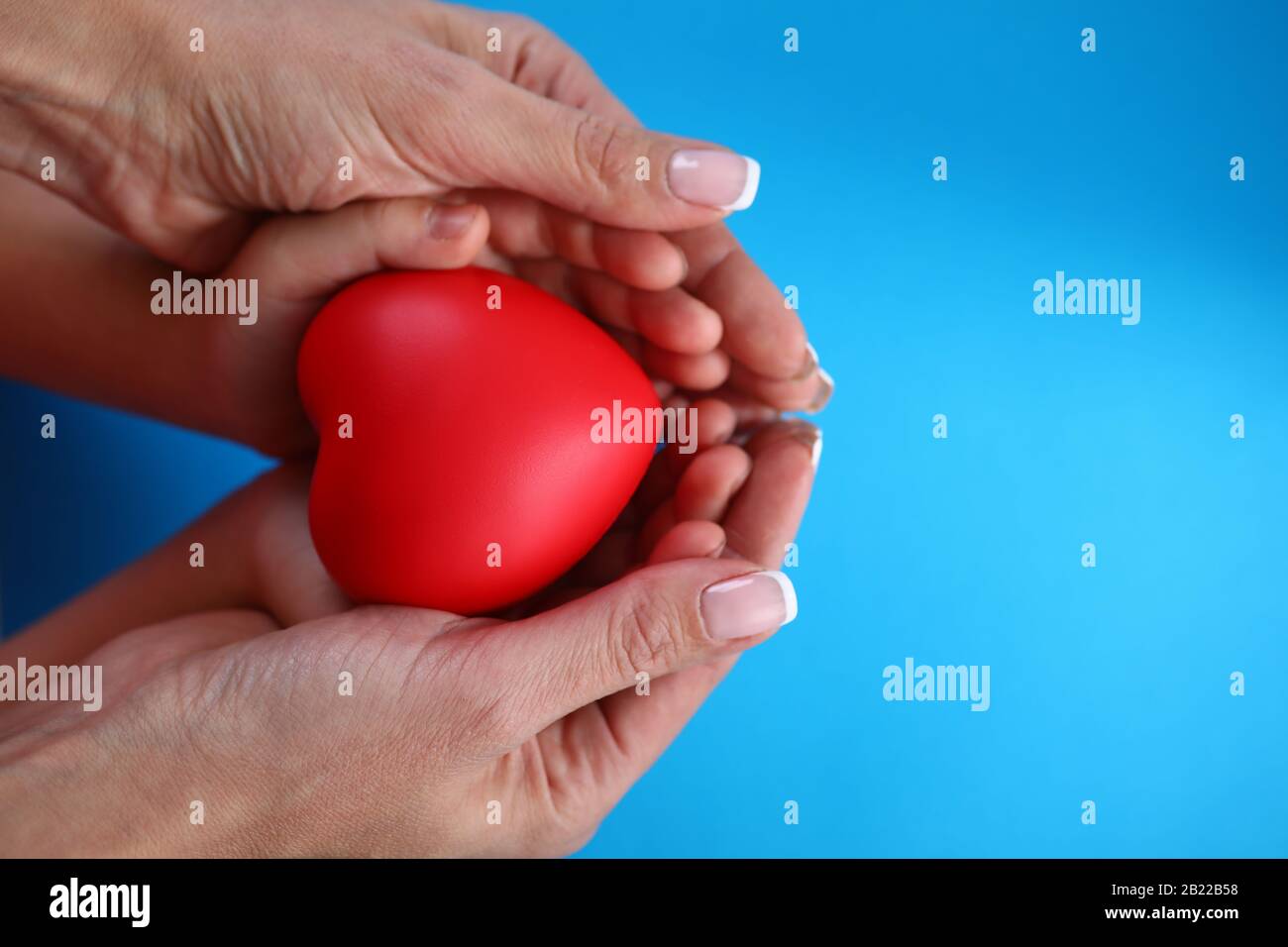 Close-up in female palms childrens hands and heart Stock Photo