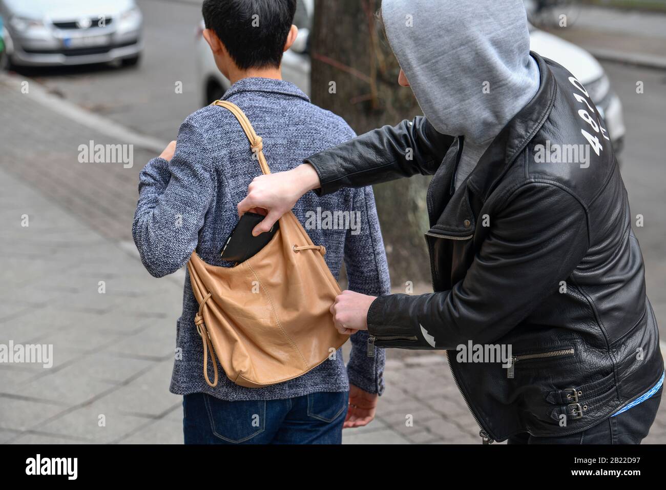 Diebstahl einer Geldbörse aus einer Handtasche, Straßenkriminalität,  gestelltes Foto Stock Photo - Alamy