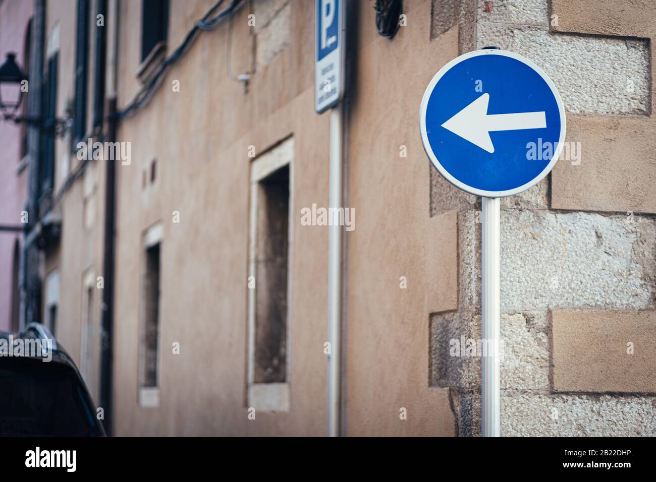 Left arrow blue traffic signal on a street Stock Photo