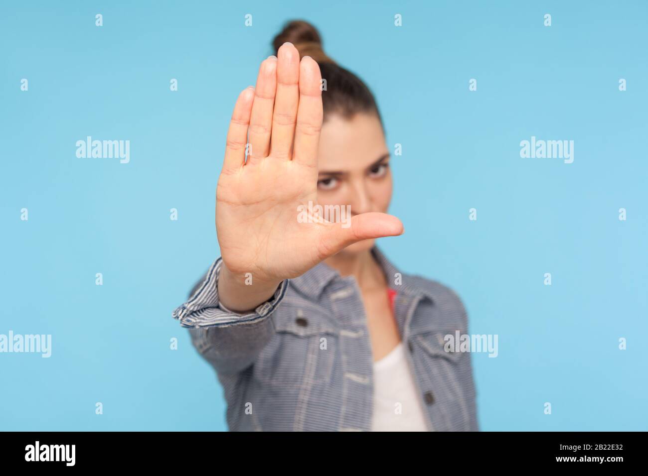 No, it's forbidden! Portrait of young serious woman showing stop sign with outstretched palm, warning with negative bossy expression, prohibition ban Stock Photo