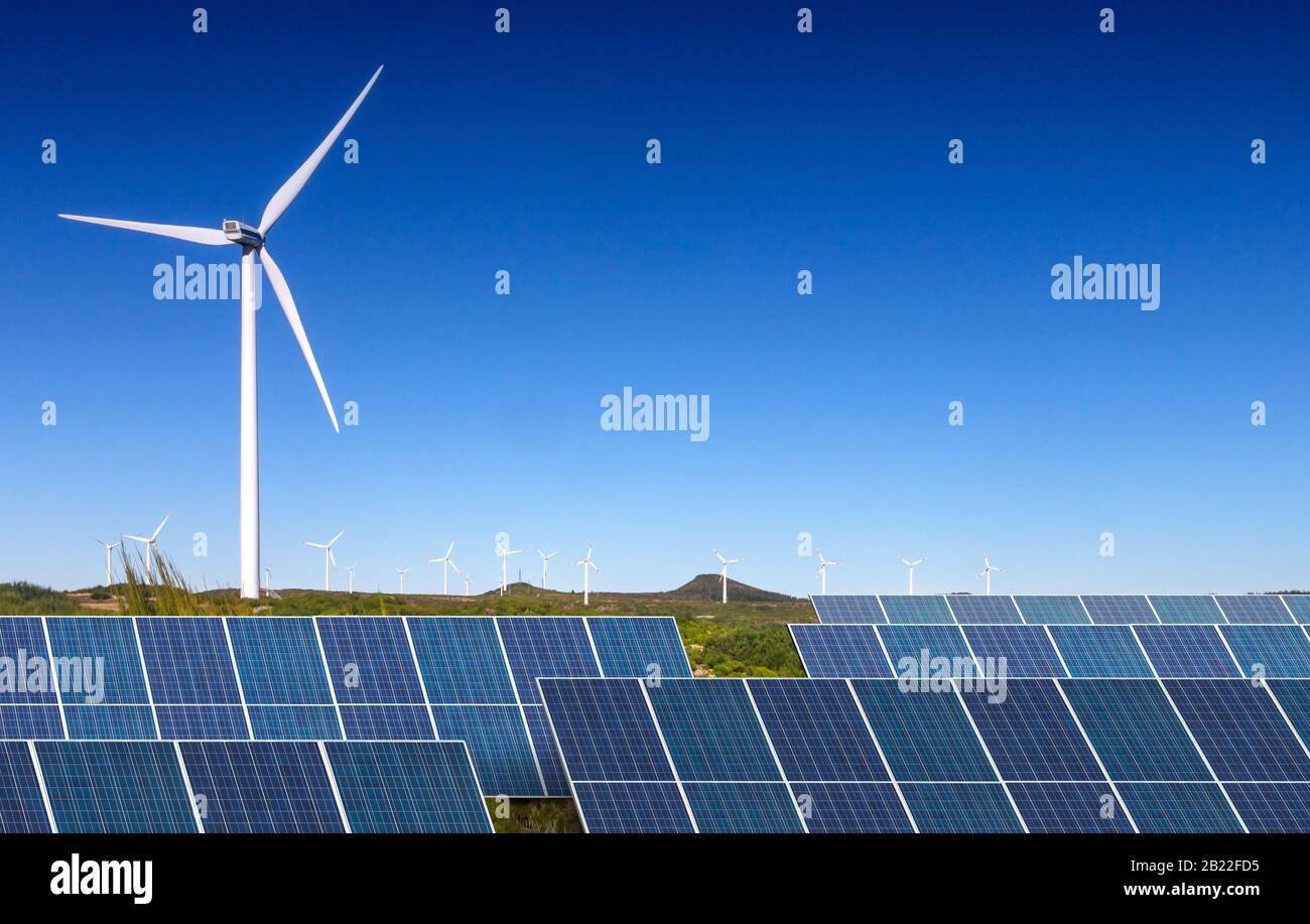 solar panels with wind turbines against blue sky Stock Photo - Alamy