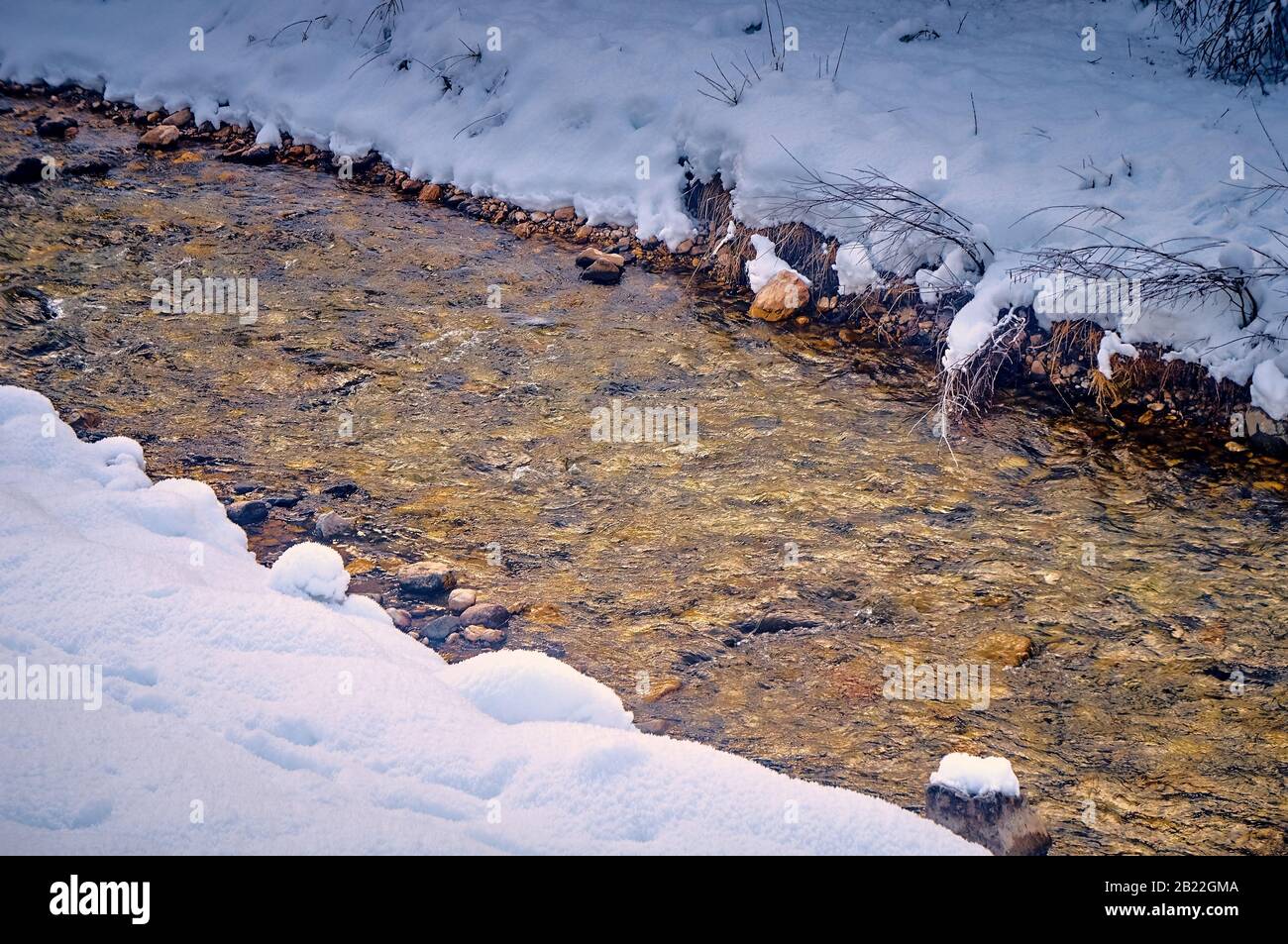 mountain stream flowing in winter among snow and stones Stock Photo - Alamy