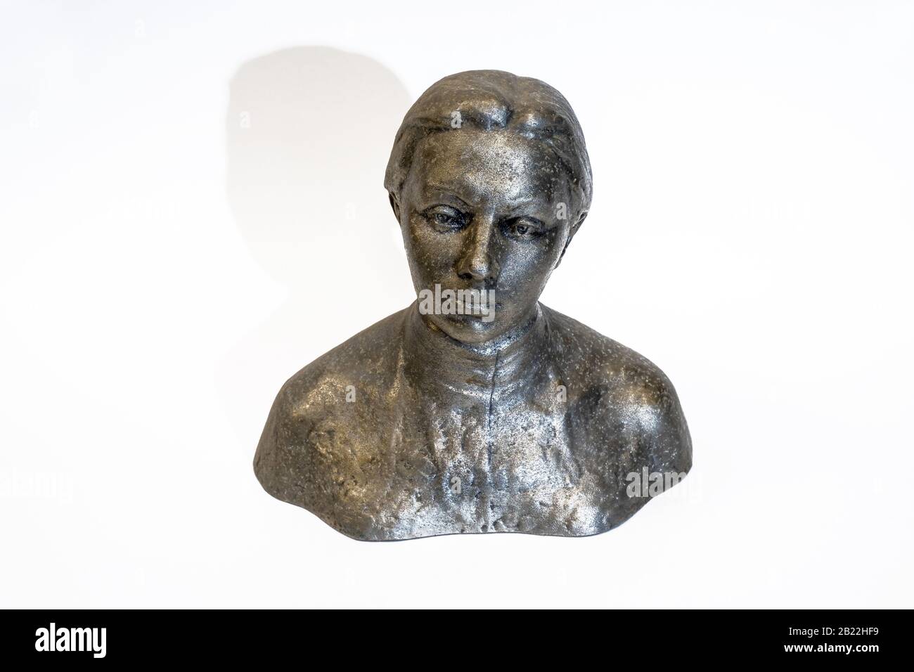 A small metal antique bust of Nadezhda Krupskaya on a white background, close-up shot. Stock Photo