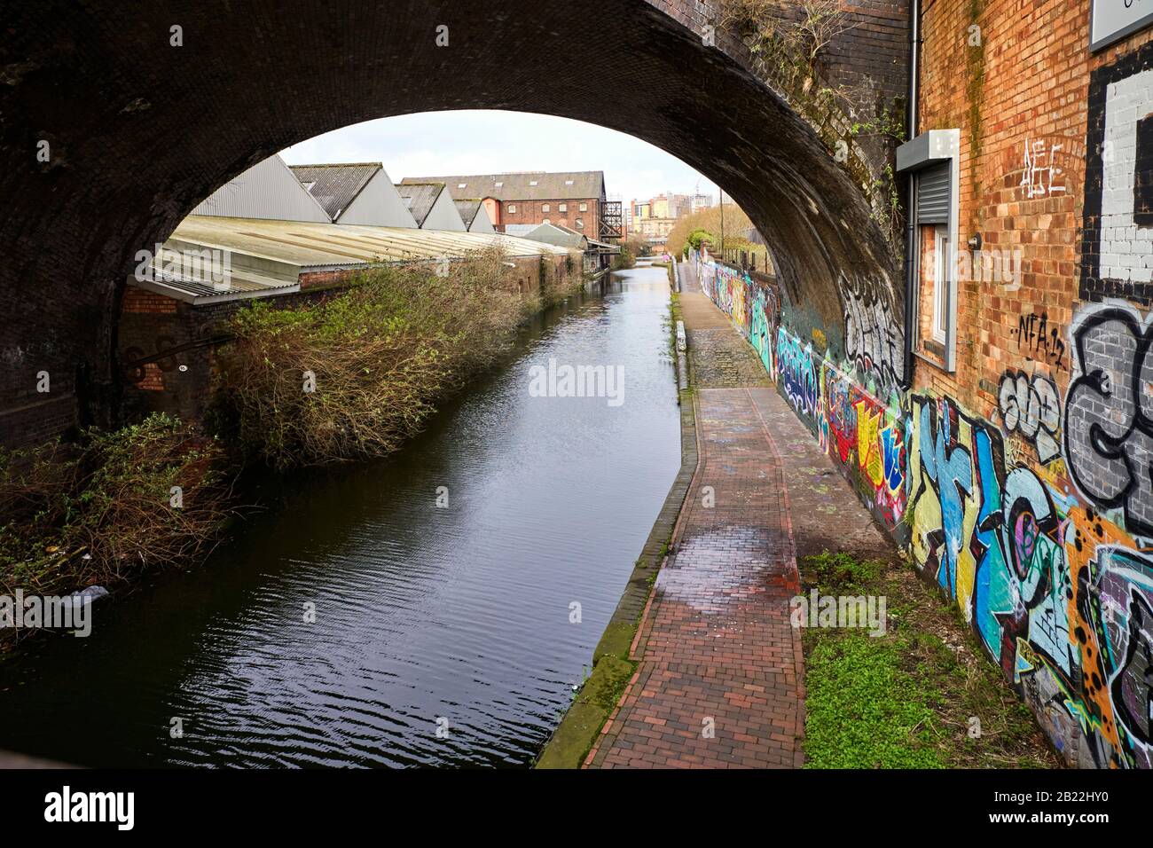 Digbeth Branch Canal going under the disused railway bridge 95a viewed from Great Barr Street in Digbeth, Birmingham Stock Photo