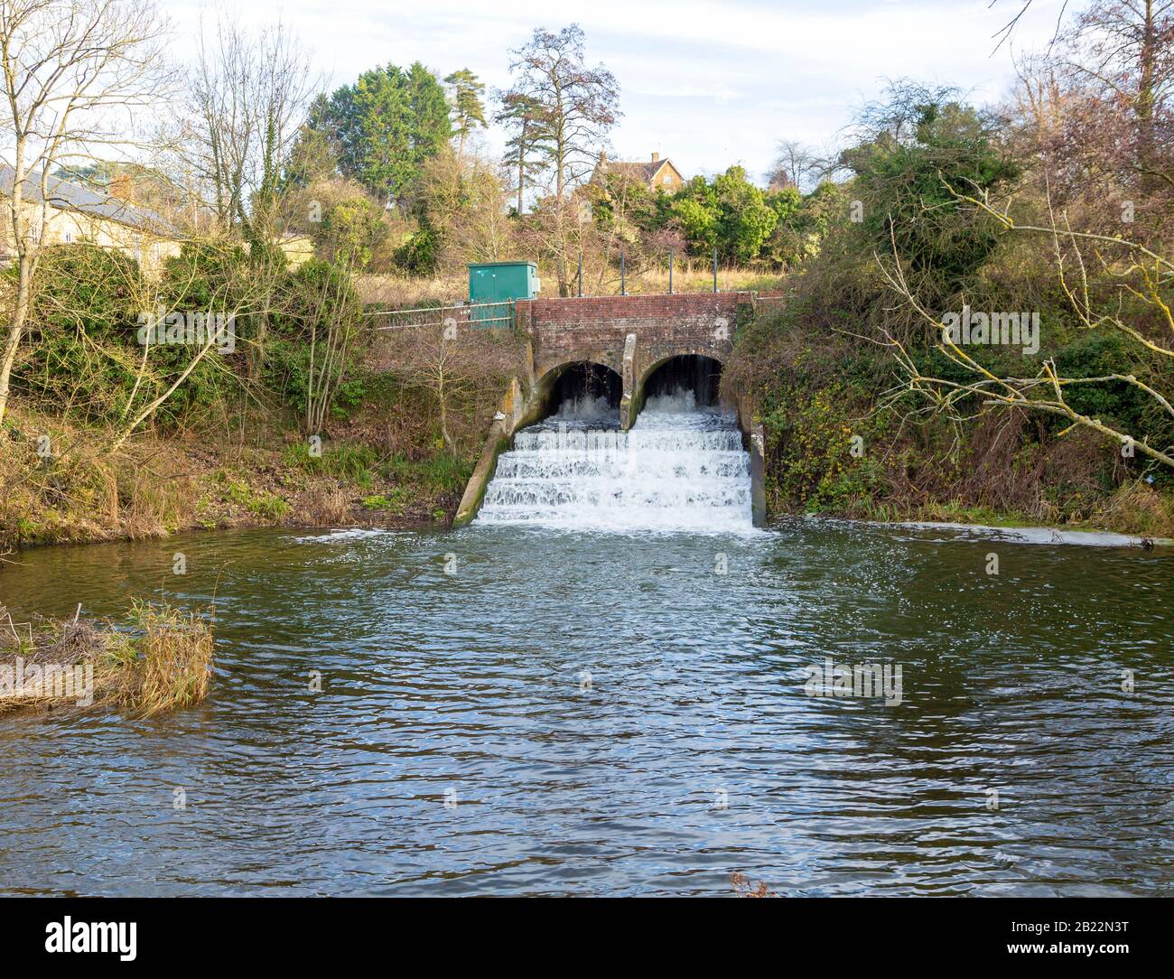 Bridge and weir with rushing water on River Marden, Bremhill, Calne
