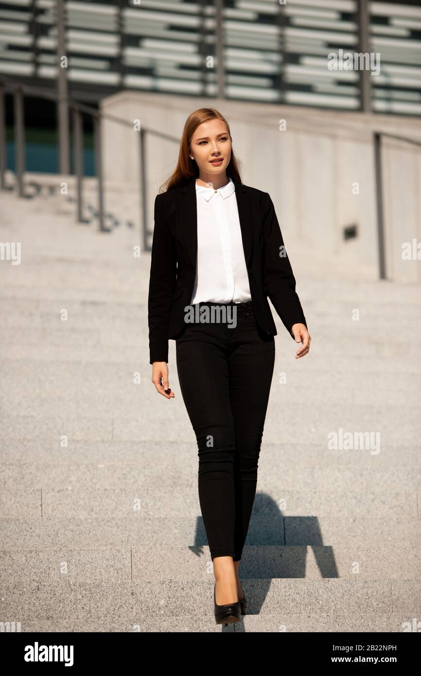 Young business woman walk on stairs leaving office building . Stock Photo