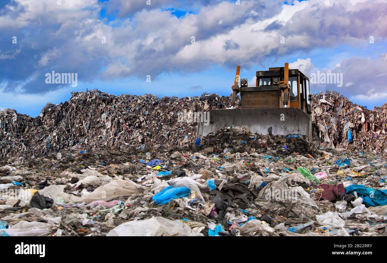 bulldozer working on landfill with waste Stock Photo