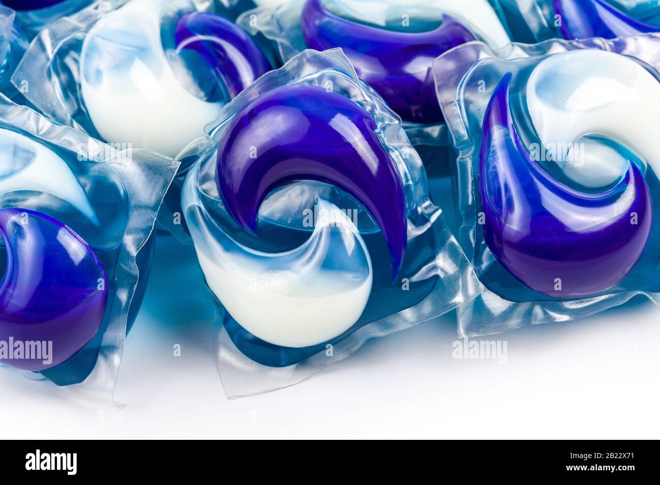 A pile of washing dishwasher or laundry blue white chemical detergent pods, packs, pouches closeup macro detail. Household items, objects concept, set Stock Photo