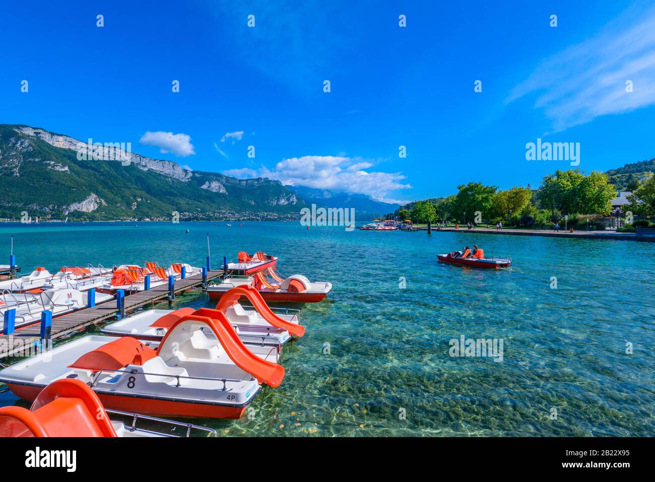 Pedal boats on Lake Annecy, one of the largest lakes in France known as the cleanest lake in Europe, viewed from Jardins de l'Europe park. Stock Photo