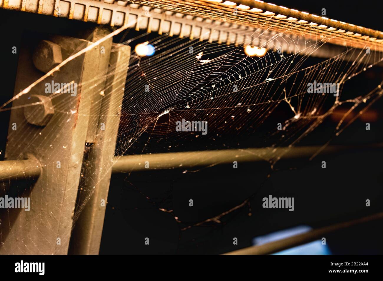 A spider web on metal railings awaits the built-in light. Stock Photo
