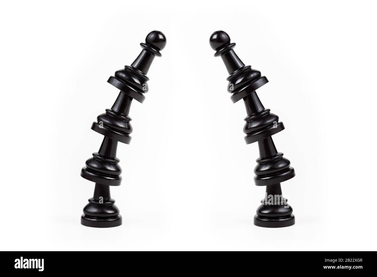 Two leaning crooked bent towers of black chess pawns forming a gate