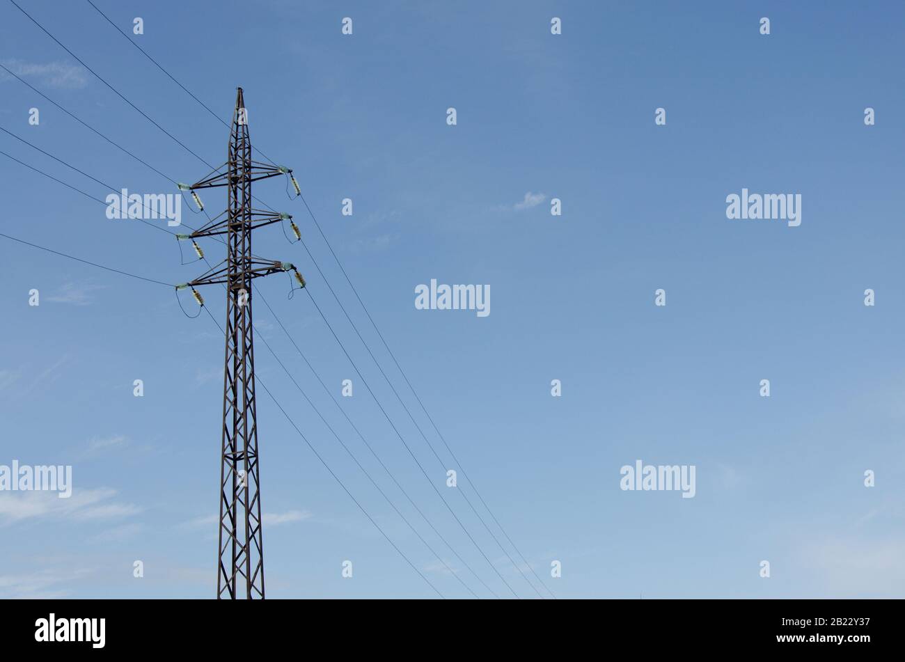 High voltage power line against a blue sky with a cloud Stock Photo - Alamy