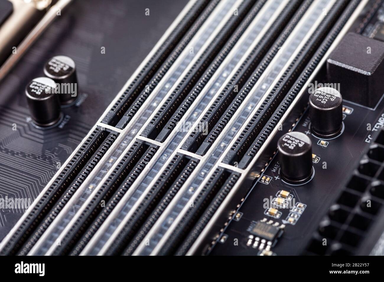 Closeup on empty RAM slots on a modern black silver motherboard. Ddr4, ddr5 random access memory stick slots, ram placing order. Macro electronics Stock Photo