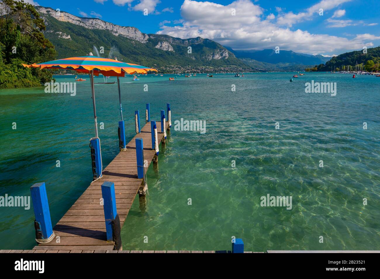 A jetty and pedal boats on Lake Annecy, one of the largest lakes in France known as the cleanest lake in Europe, viewed from Jardins de l'Europe park. Stock Photo