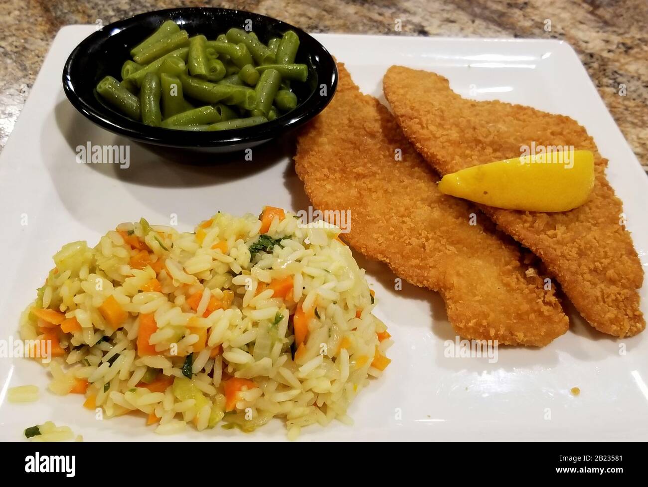 Fried flounder with wild rice and green beans Stock Photo Alamy