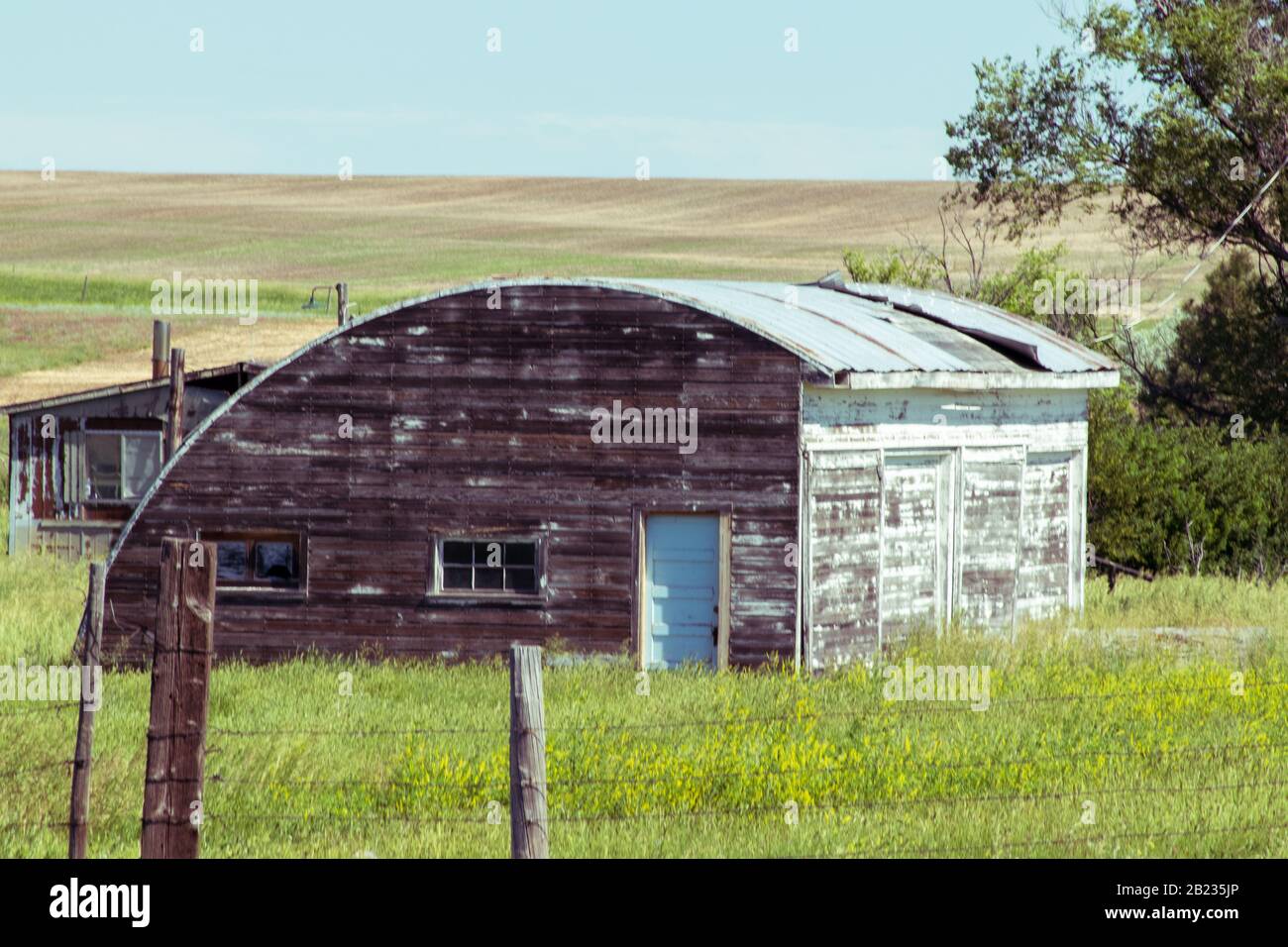 A old abandon house with a fence in a grassy field. High quality photo Stock Photo