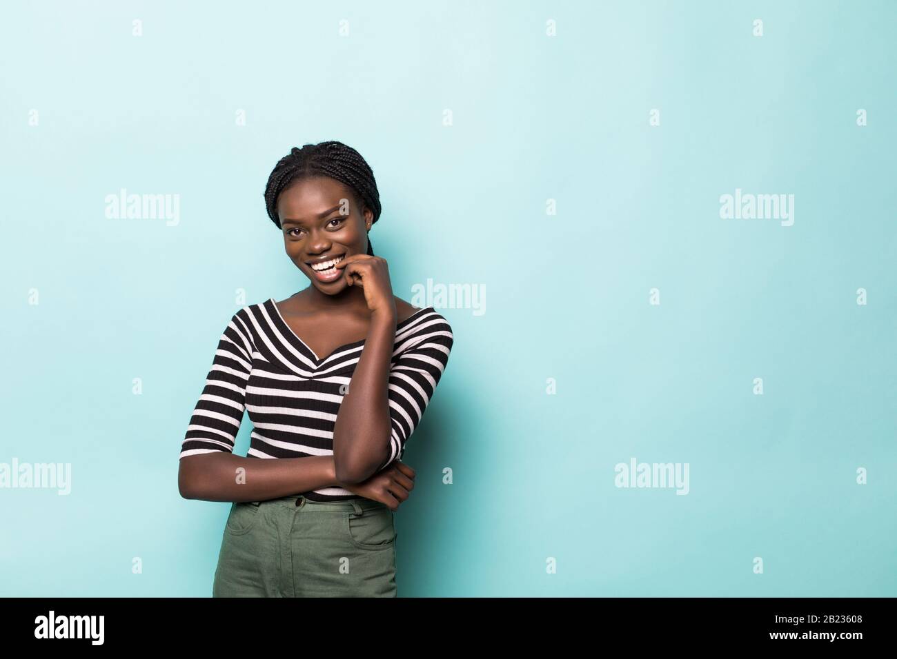 Portrait of beautiful african woman smiling against blue wall Stock ...