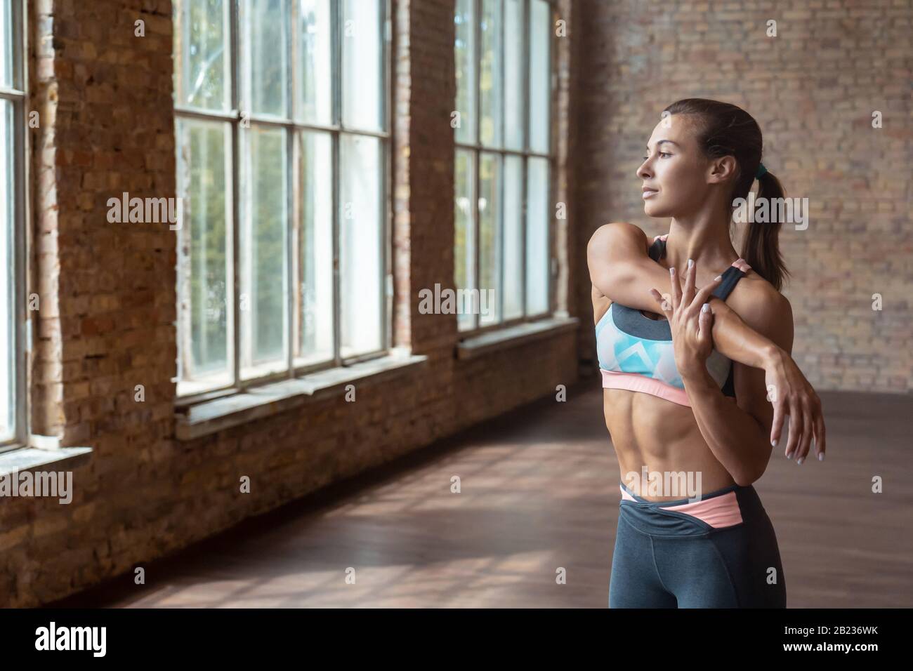 Sporty young woman fitness coach warm up stretch hand. Stock Photo
