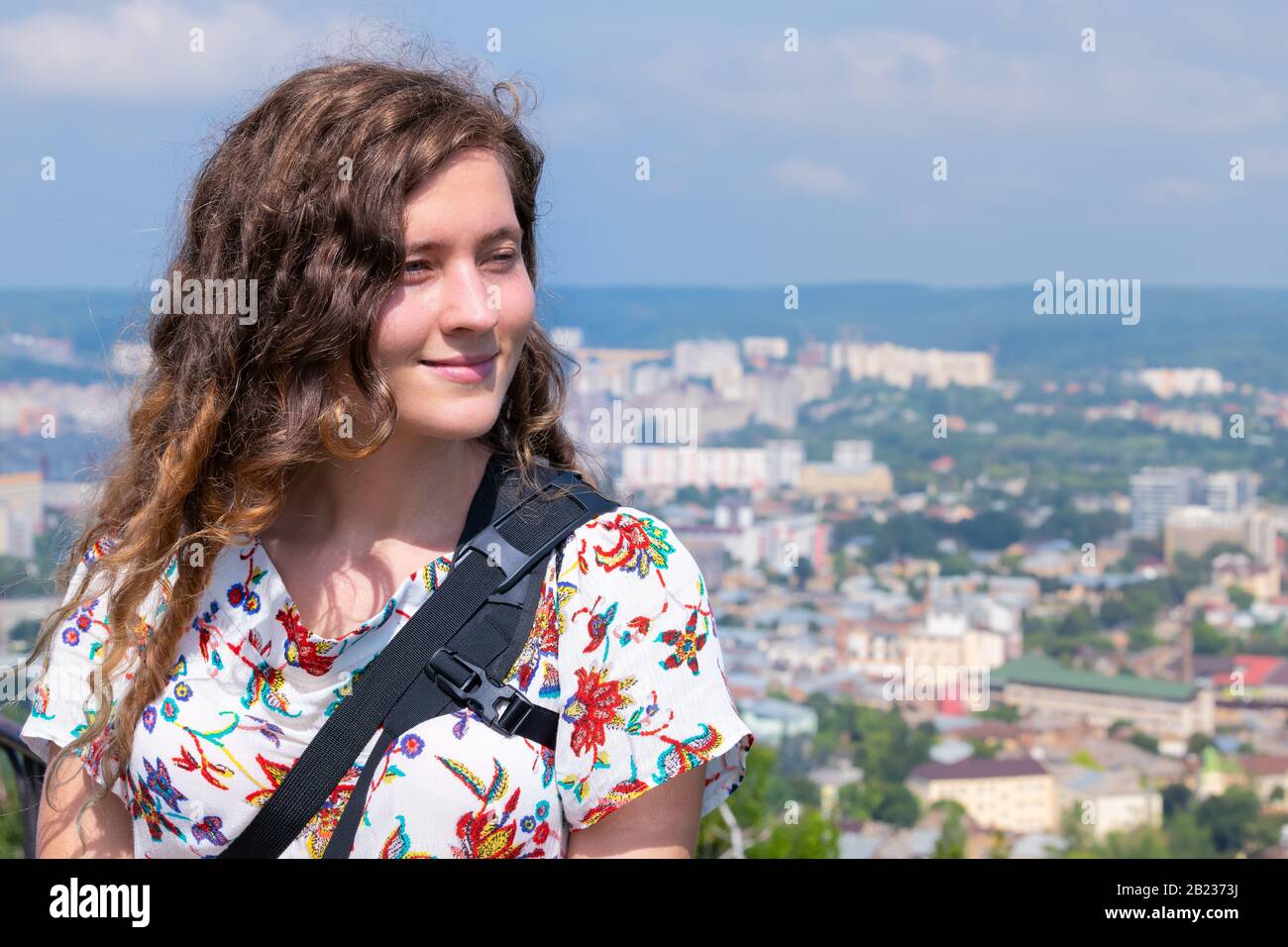 Lviv, Ukraine and young woman tourist looking at cityscape skyline in historic Ukrainian city old town buildings architecture during sunny summer day Stock Photo
