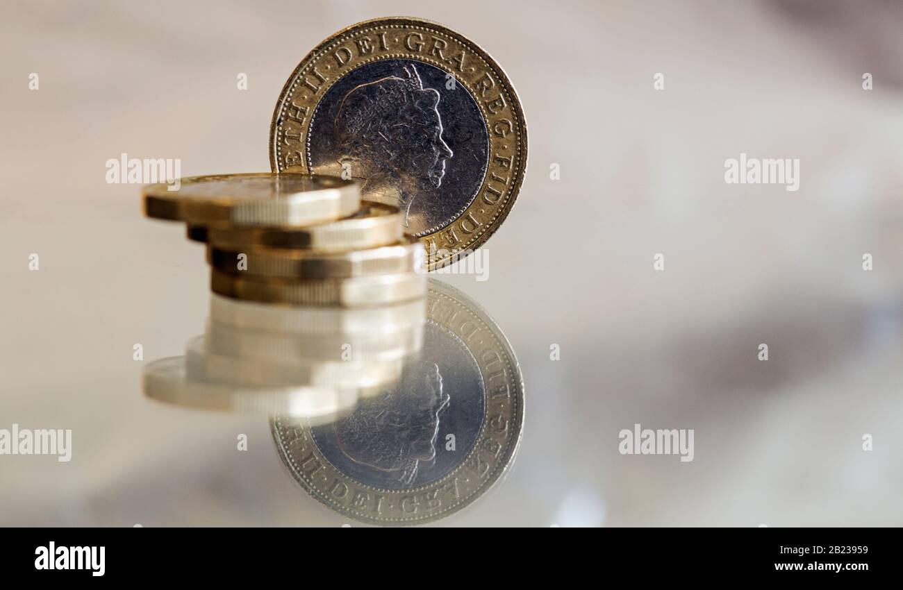 UK Pound coins and a £2 coin shot macro on a reflective surface Stock Photo