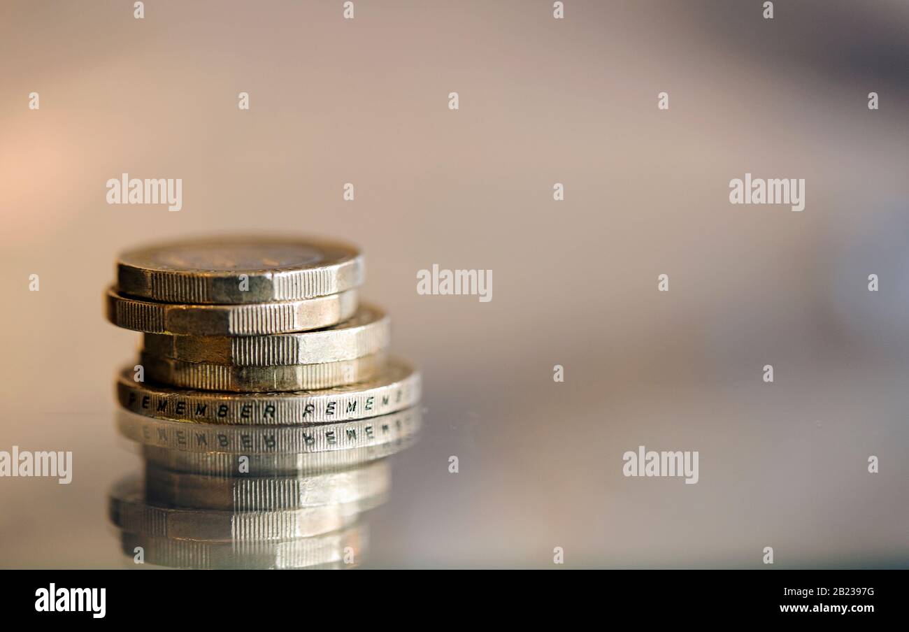 UK Pound coins and a £2 coin shot macro on a reflective surface Stock Photo
