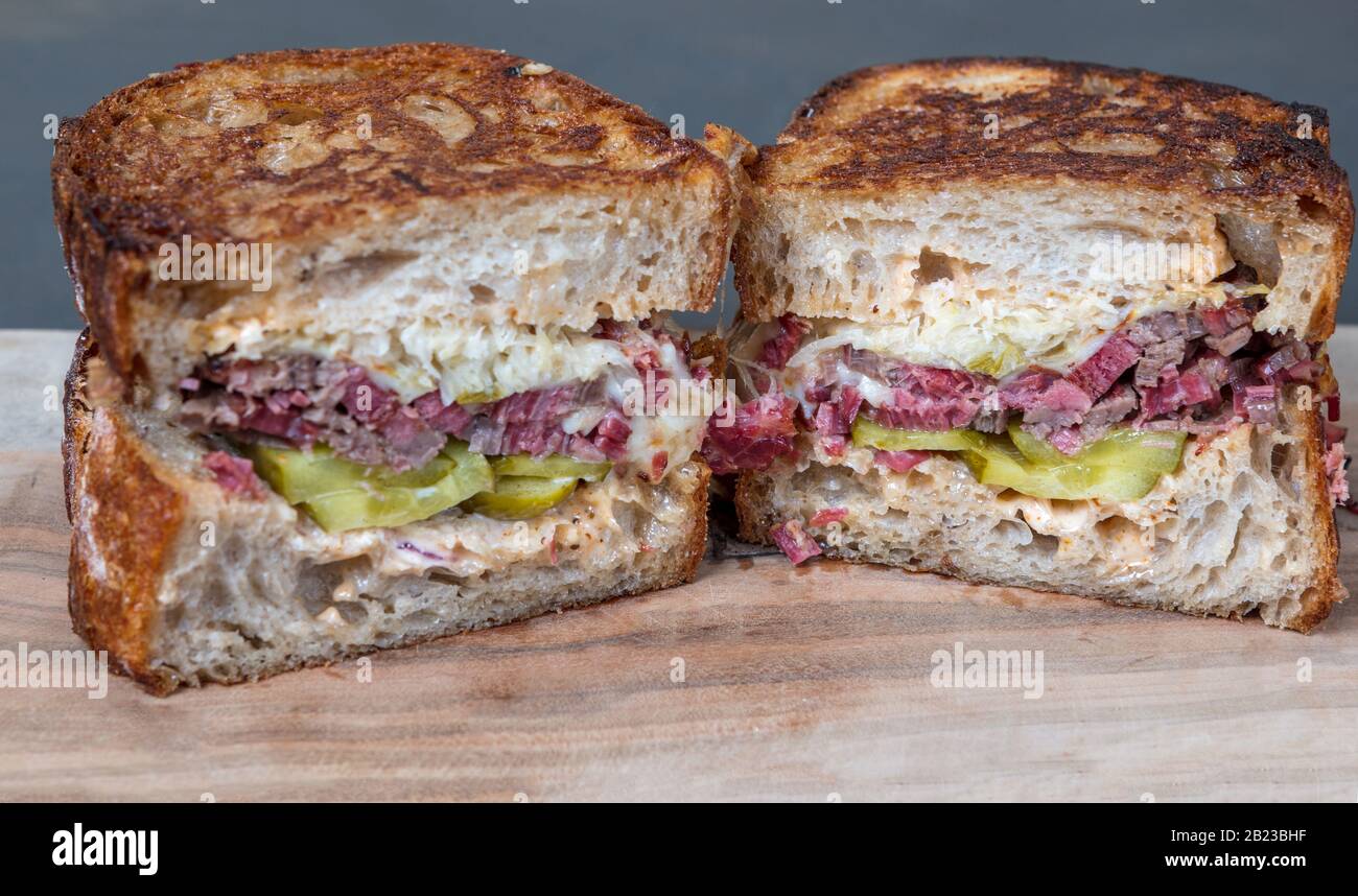 Close Up Of Salt Beef Reuben Sandwich Pastrami Toasted Sourdough Bread Beef Brisket Coleslaw And Pickles On Wooden Board Shallow Depth Of Field Stock Photo Alamy