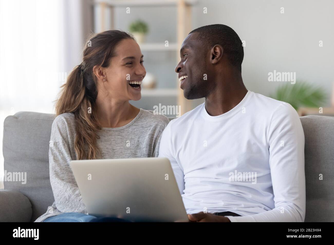 Happy African American couple having fun, using laptop Stock Photo - Alamy