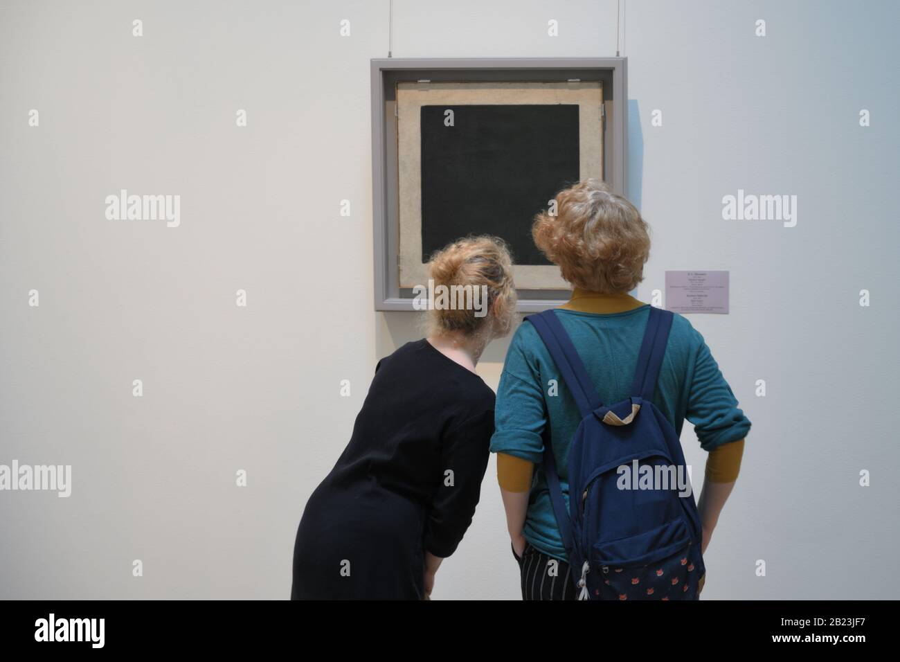 People in the General Staff building of the State Hermitage museum near iconic   Kazimir Malevich  painting Black square. Stock Photo