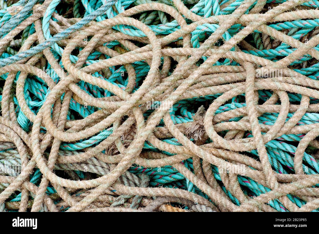 An abstract image of a pile of tangled ropes discarded on the quayside. Stock Photo