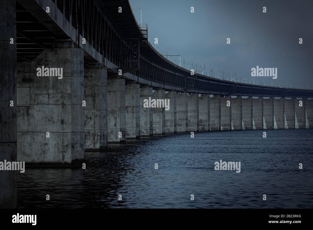 The concrete pillars holding up the Öresund bridge on a dark gloomy day by the sea in Malmö, Sweden Stock Photo