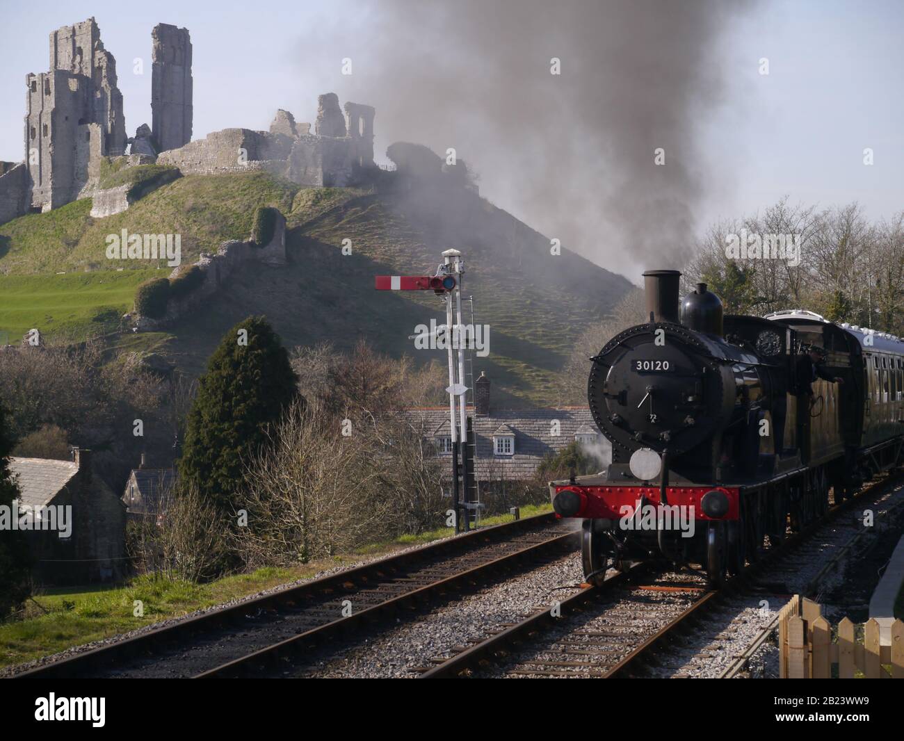 A steam train passing by Corfe Castle, United KIngdom Stock Photo