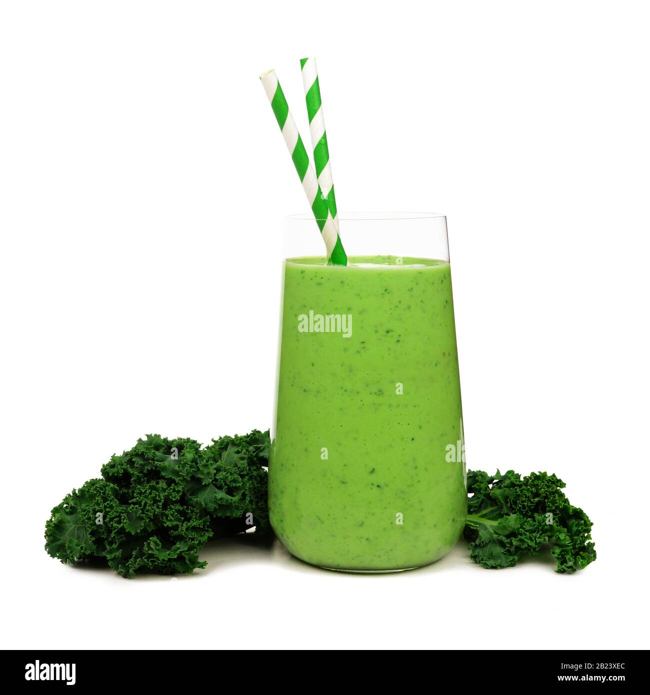 Green smoothie in a glass tumbler with kale and paper straws isolated on a white background Stock Photo