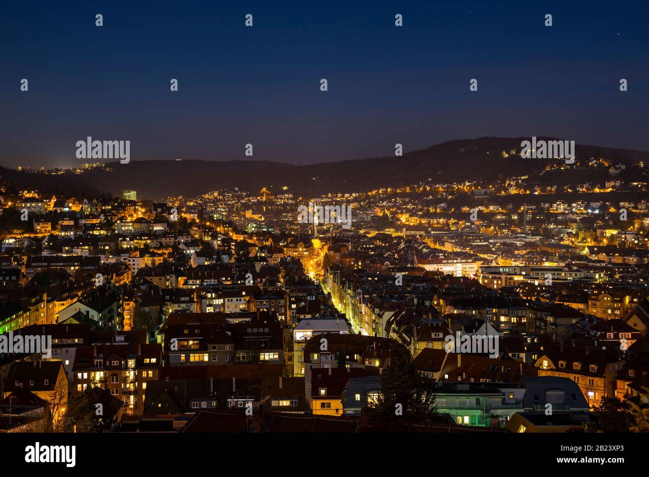 Germany, Aerial view above illuminated skyline of city stuttgart houses in basin in cold winter night with starry sky Stock Photo