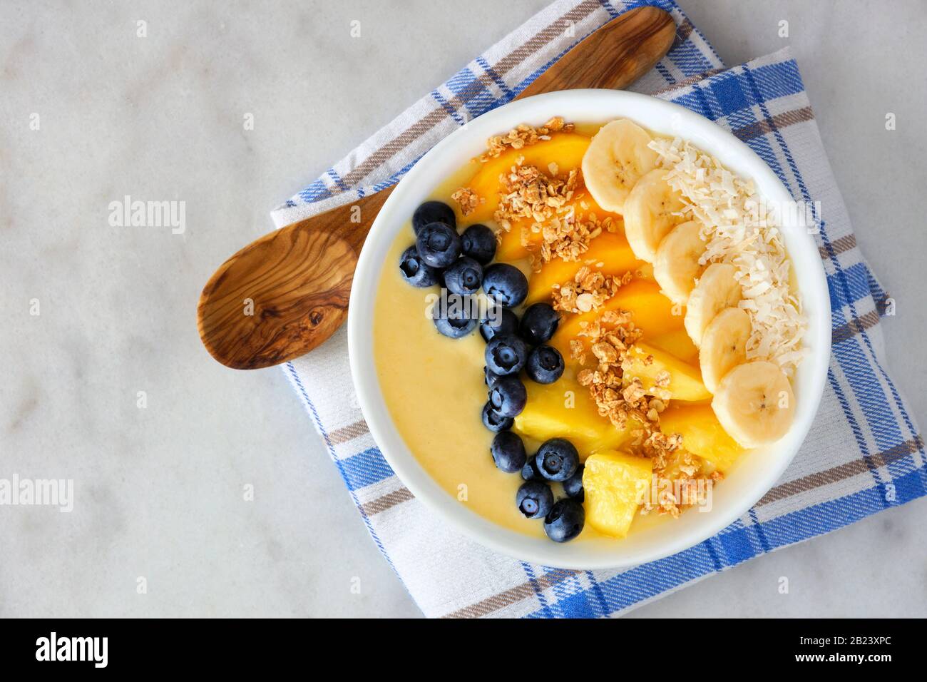 Healthy pineapple, mango smoothie bowl with coconut, bananas