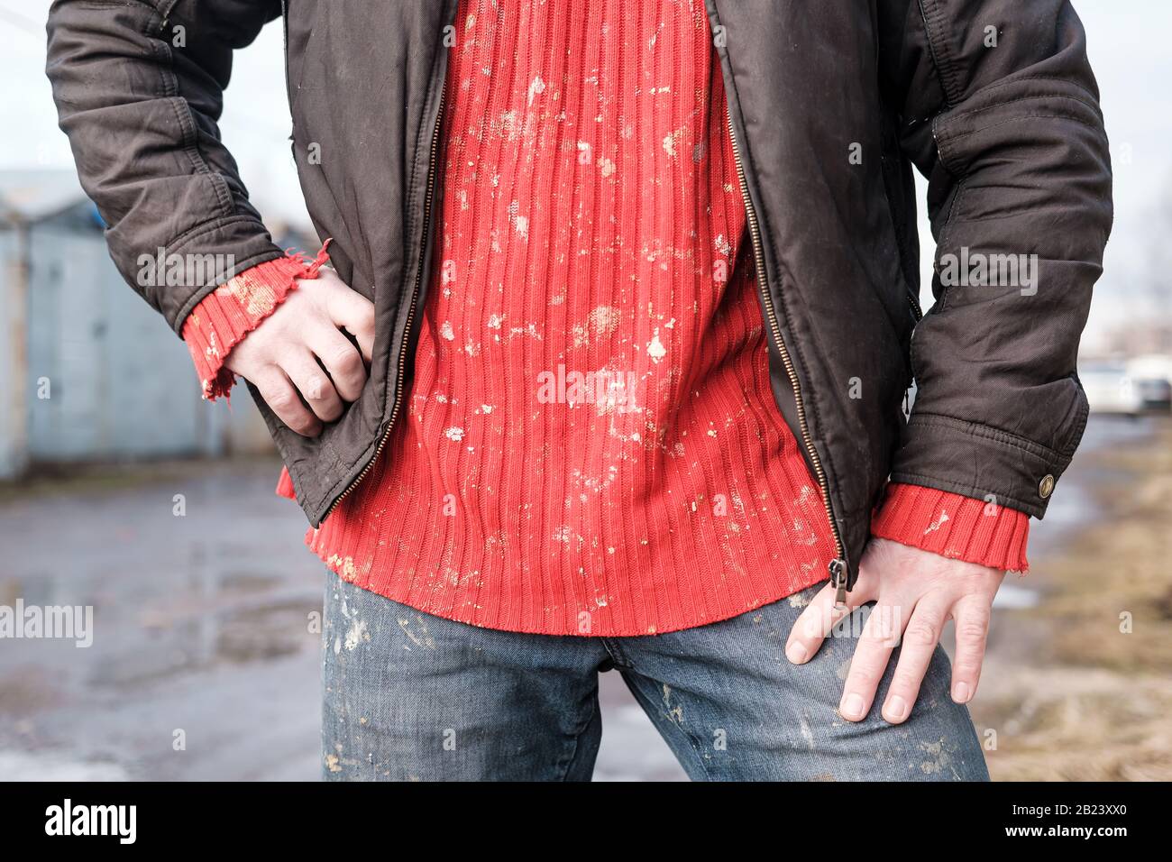 Man in dirty work clothes, a red knitted sweater and jeans. Stock Photo
