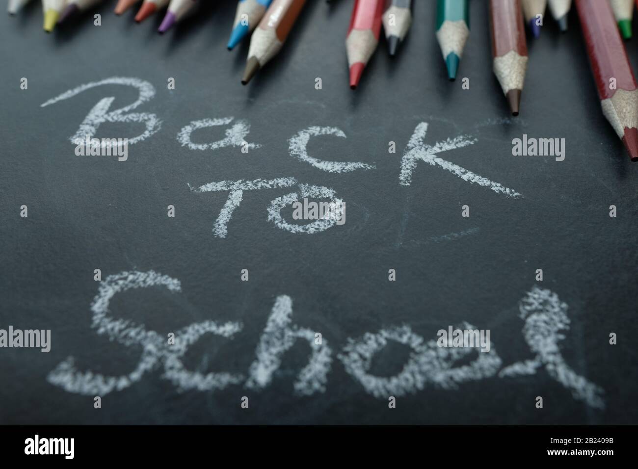 back to school concept with color pencils and text on black board  Stock Photo