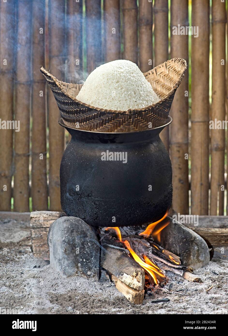 Traditional rice cooker over open fire, sticky rice cooking in a bamboo  basket over simmering water, Living Land Rice Farrm near Luang Prabang,  Laos Stock Photo - Alamy