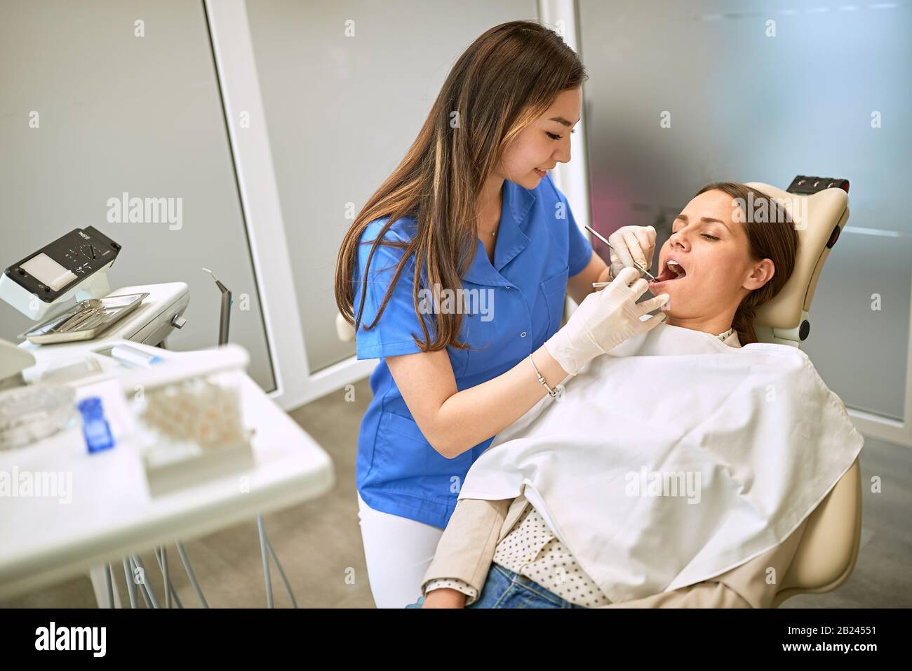 Young female in dental chair repairing tooth Stock Photo