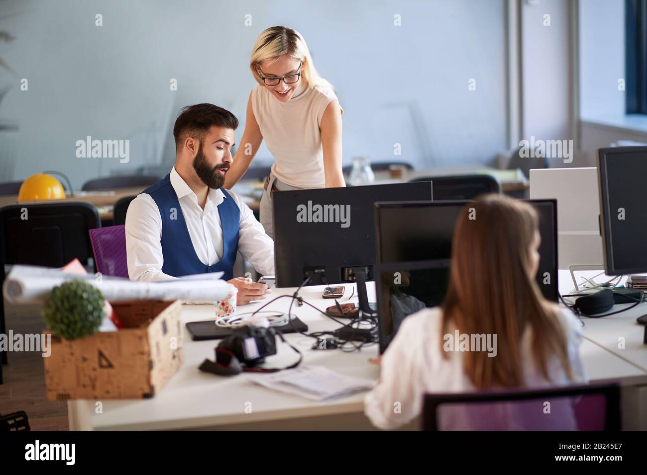 Happy business people having fun while working together on joint project . Stock Photo