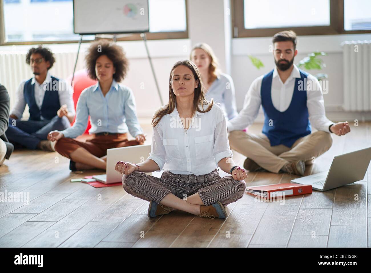 Businesswoman meditating at work.group of business coworkers meditating together at work. Stock Photo