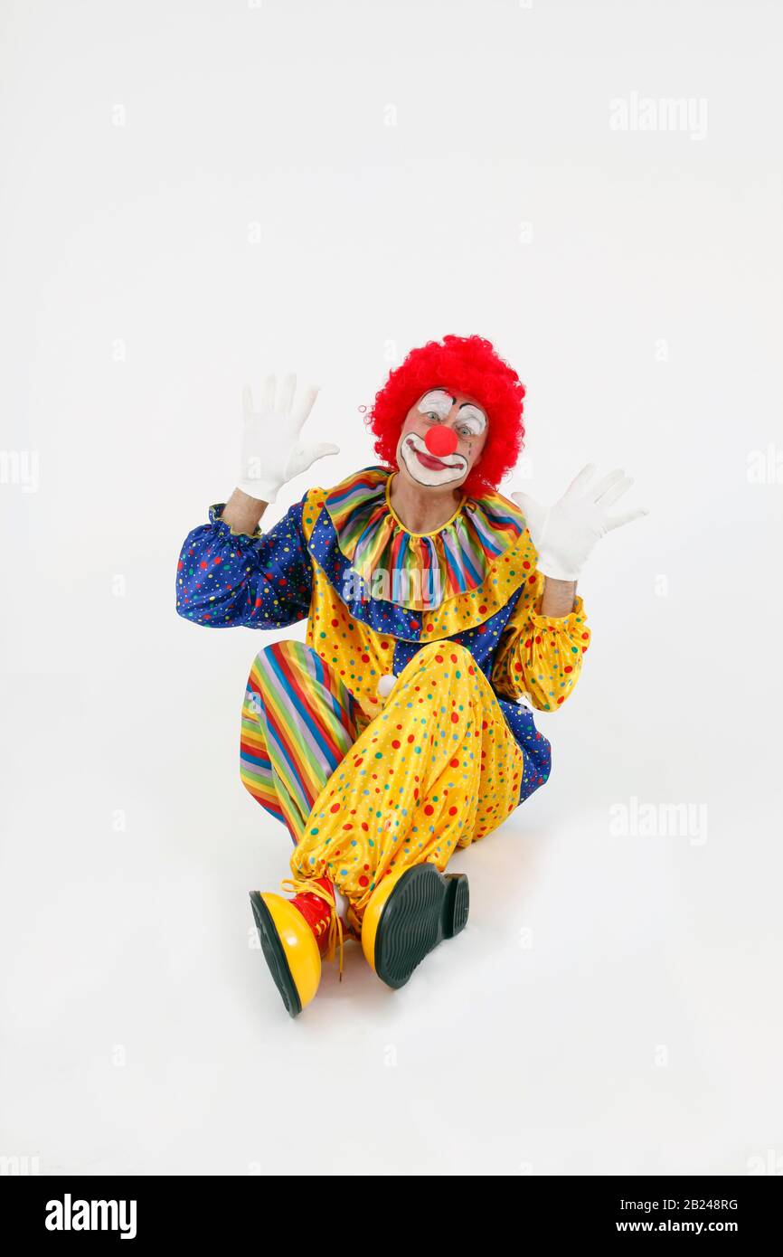 Clown sitting and waving, Germany Stock Photo