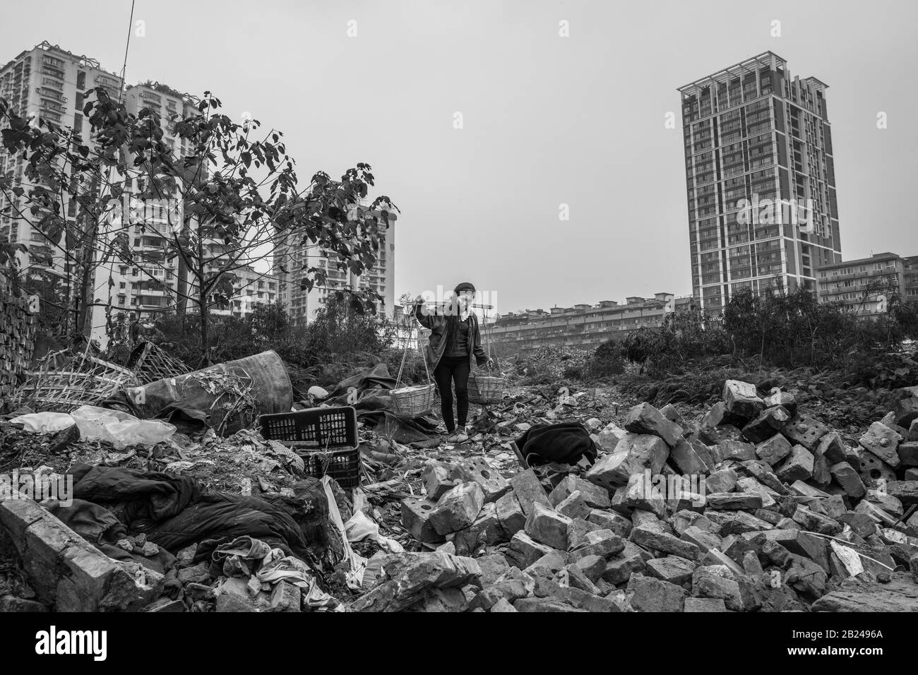 Street scene in an old town quarter of Chongqing. A woman recovering building materials from a demolition house, Chongqing, China Stock Photo