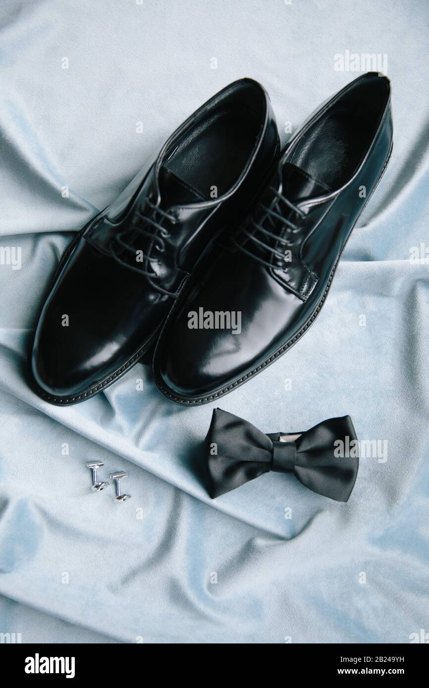 Groom accessories. Shoes, bow tie, and cufflinks. On the blue background. Stock Photo