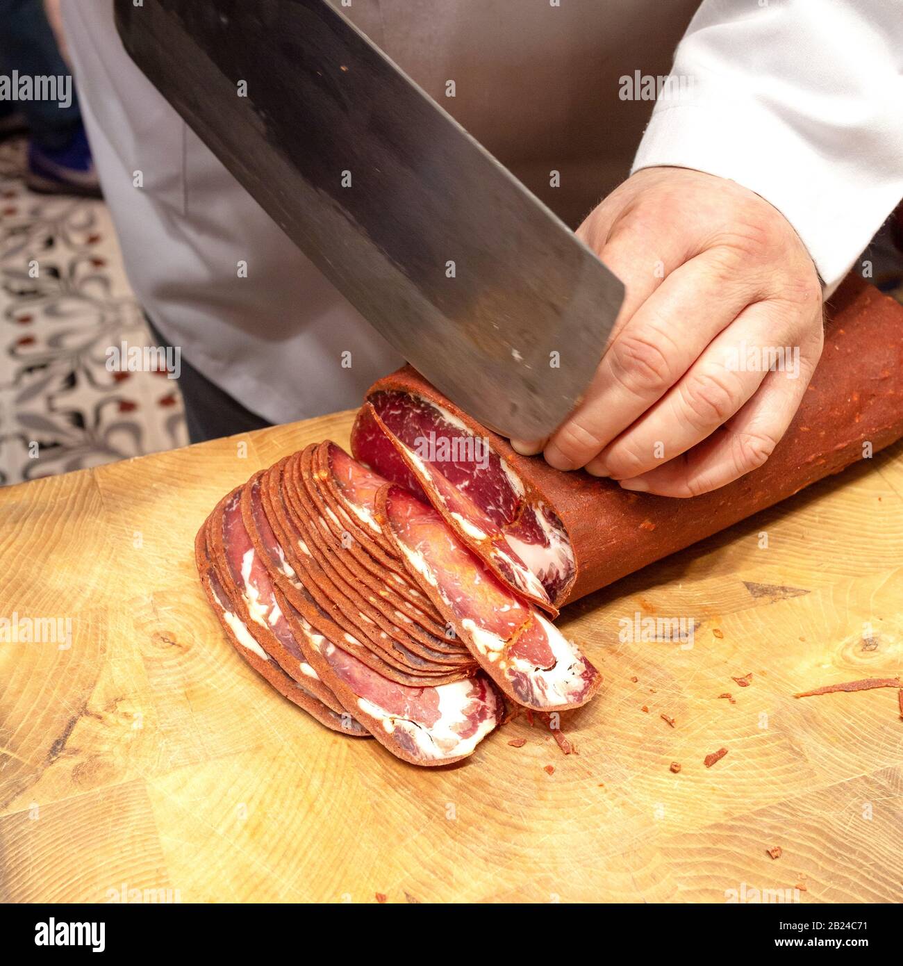 A Vendor slices bacon to his client. Egyptian Bazaar, Istanbul, Turkey. Stock Photo
