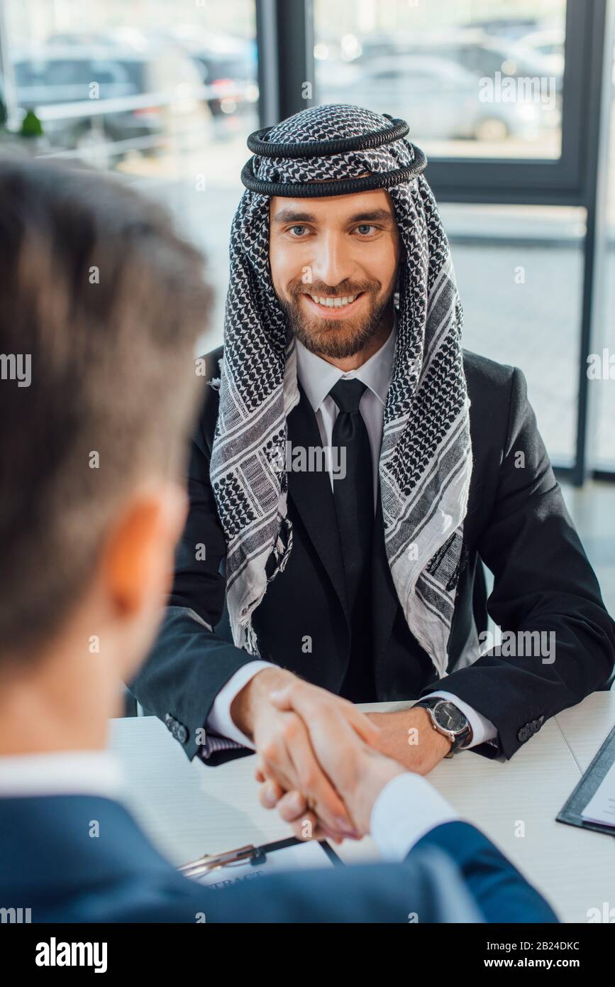 Smiling Multiethnic Businessman Shaking Hands With Partner On Meeting