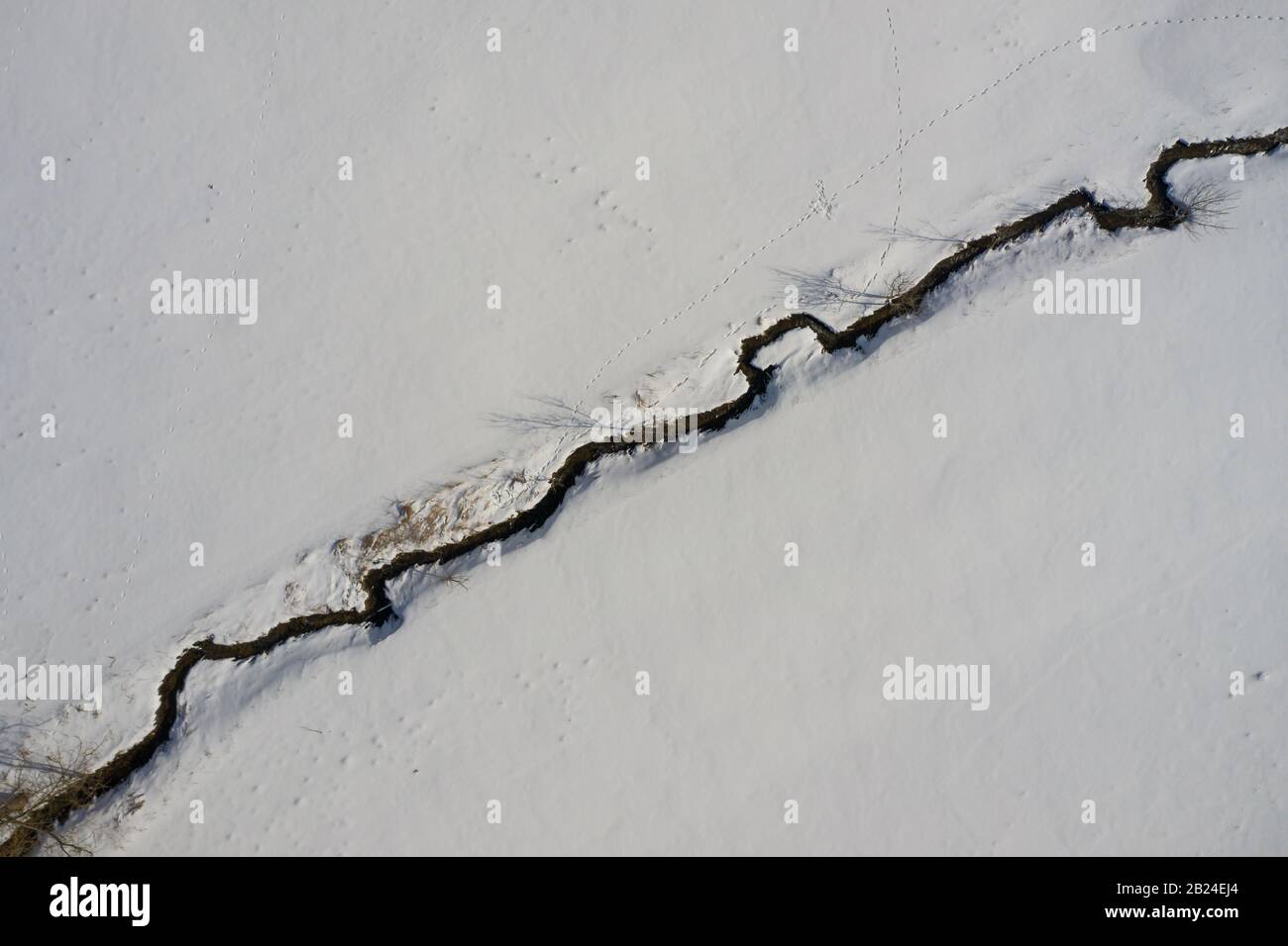 An aerial winter top shot at a little creek river snow framed, pure ...