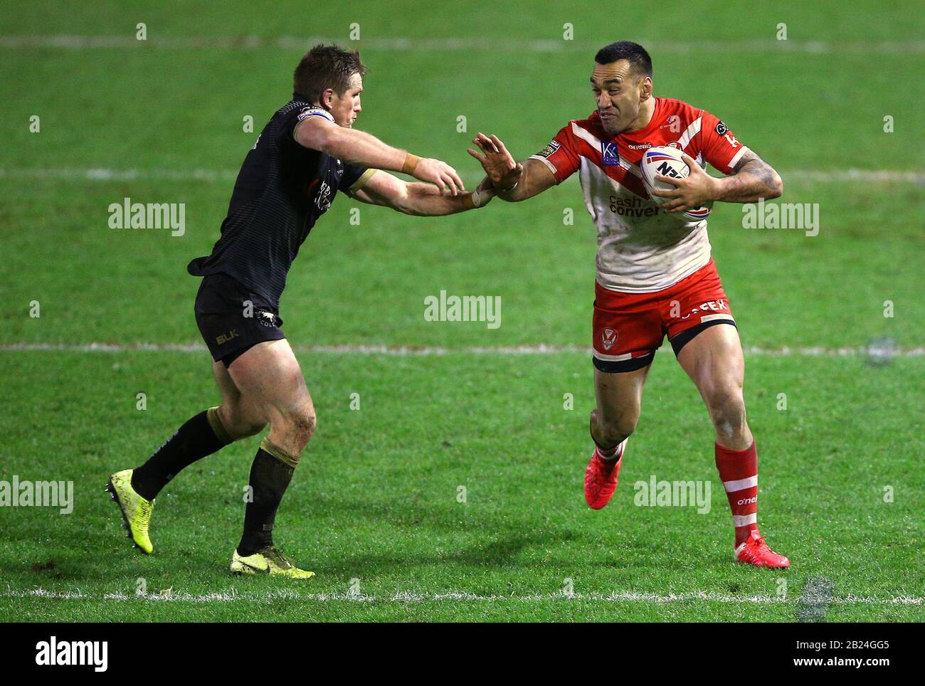Toronto Wolfpack's Josh McCrone (left) tackles and St Helens' Zeb Taia during the Betfred Super League match at Halliwell Jones Stadium, Warrington. Stock Photo
