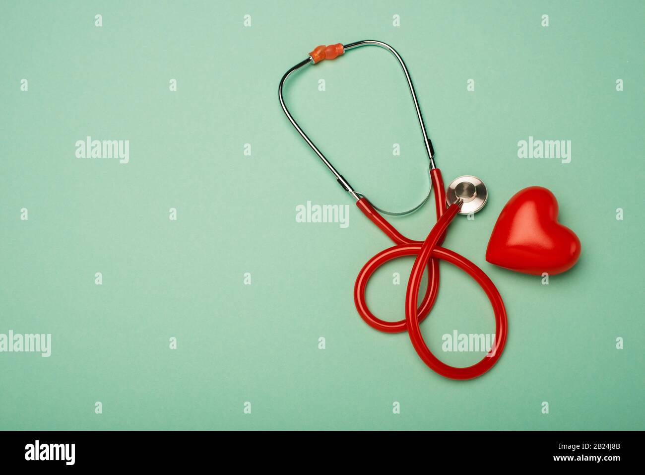 Top view of stethoscope next to red heart on green background, world ...