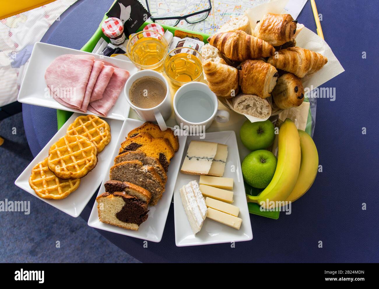 Beautiful continental breakfast served for two person and consisting of croissans, rolls, fruit, orange juice, coffee, tea, several types of cheese an Stock Photo