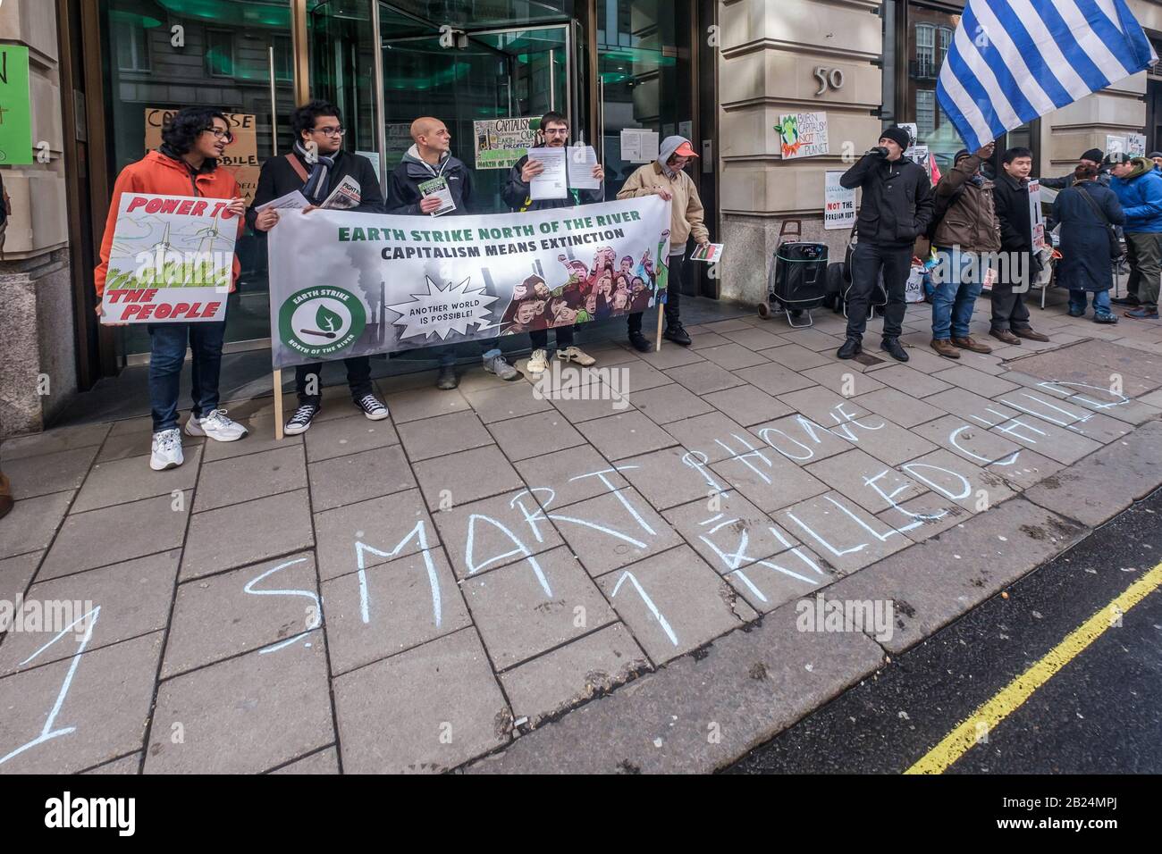 London, UK. 29th February 2020. '1 Smart Phone = 1 Killed Child'.Earth Strike and other climate activists protest at the Mayfair offices of part British-owned multinational mining company Glencore.  One of the world's largest producers of coal, they profit from ecological destruction to extract minerals like cobalt, copper and lithium vital in smartphones, computers and electric cars. Congolese families are suing them over children killed or maimed in their mines, and protesters against their mining in several countries have been violently attacked by police or murdered. Peter Marshall/Alamy L Stock Photo